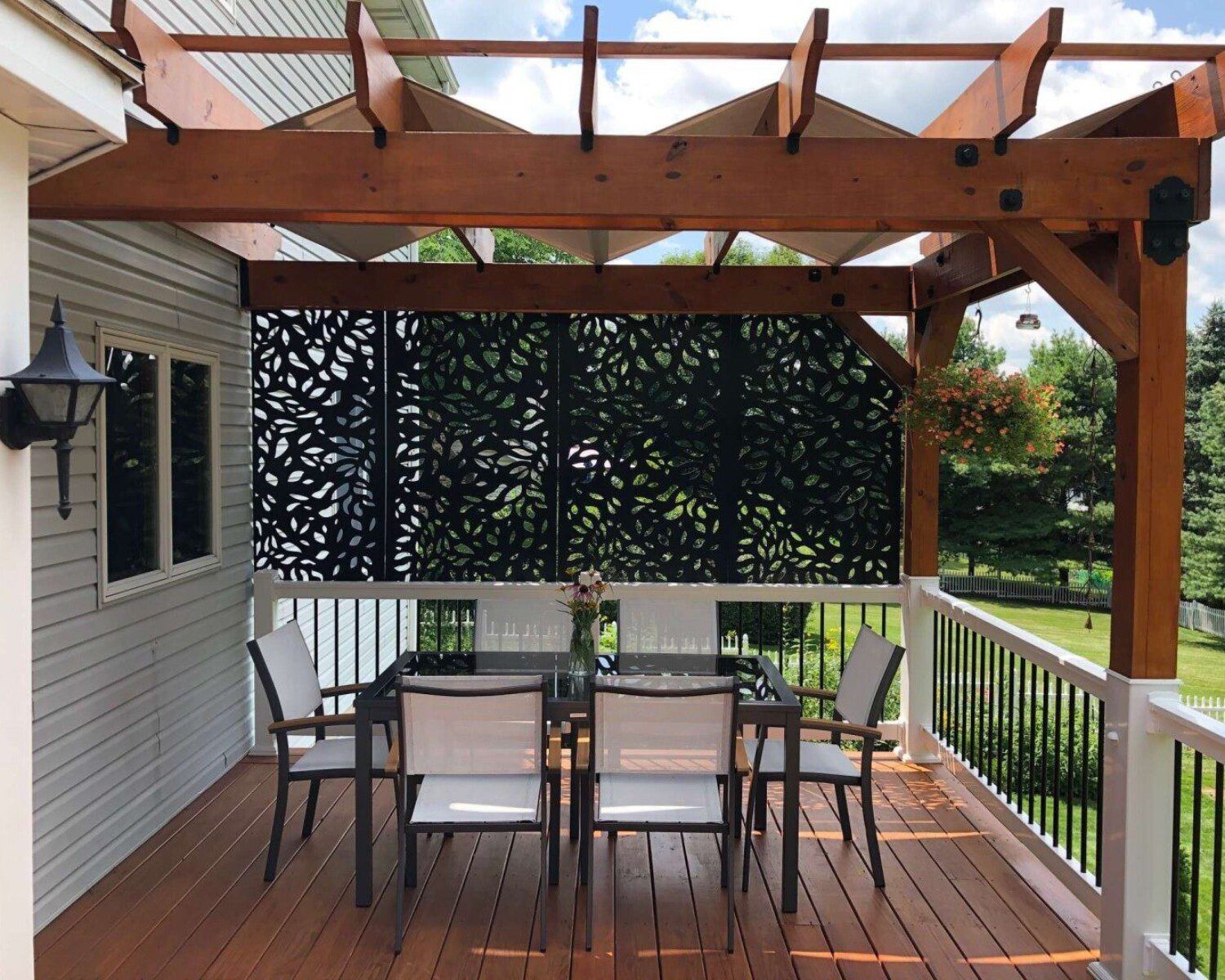 A photo of a back porch with a metal leaf design as the backwall.